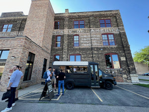 crescendo mobile coffee bar, crescendo coffee bus parked in front of an old building in an urban setting, serving guests coffee drinks.